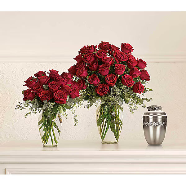 Two vases of red roses and a silver urn