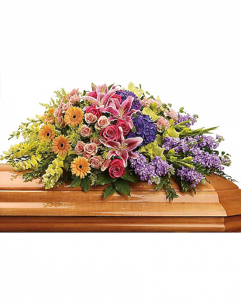 Decorative floral bouquet of mixed colors on wooden casket