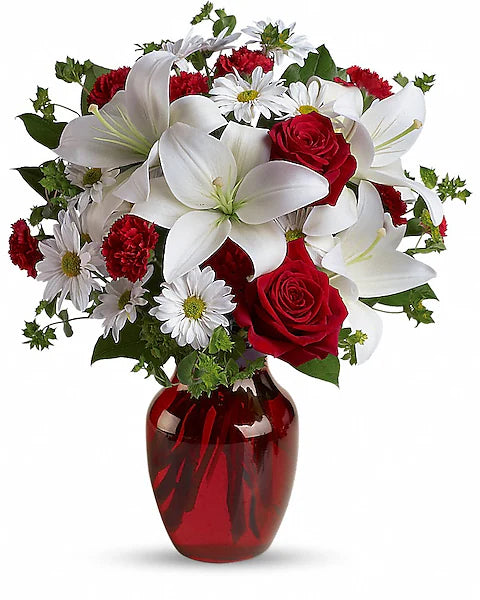 Bouquet of red and white flowers in a red vase on a white background
