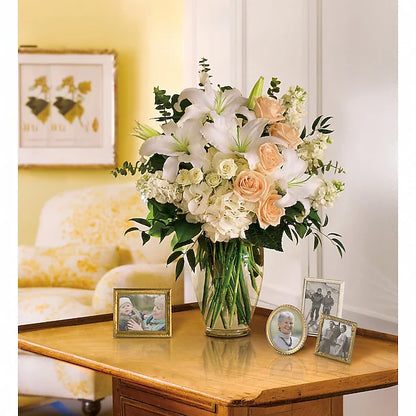 Fresh floral centerpiece on wooden table with family pictures in living room
