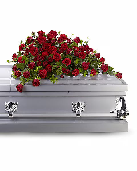 Silver casket adorned with vibrant red roses on white background