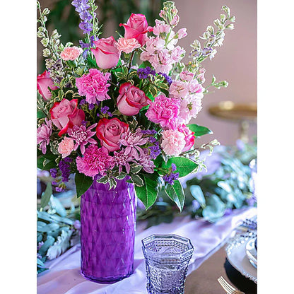 Bouquet of pink and purple flowers in a purple vase 