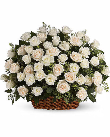 Basket of white roses and green leaves elegantly arranged on white background