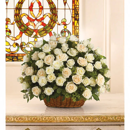 Basket of white roses in front of a stained glass window