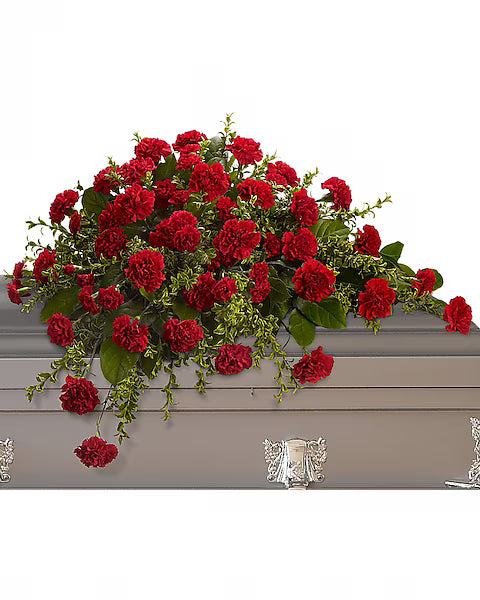 Red flowers with green leaves on a gray casket with a white background